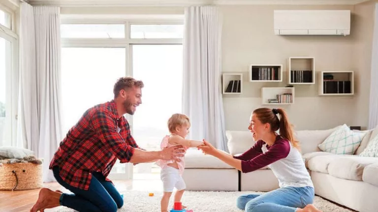 Man, a woman, and a toddler, interacting in a living room